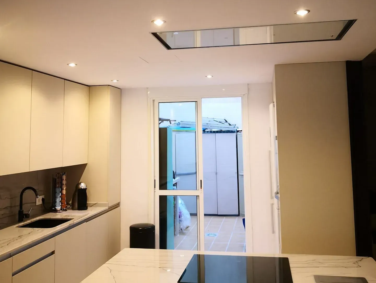 Una cocina con gabinetes blancos y un horno negro.