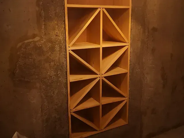 Un estante de vino de madera está colgado en una pared.