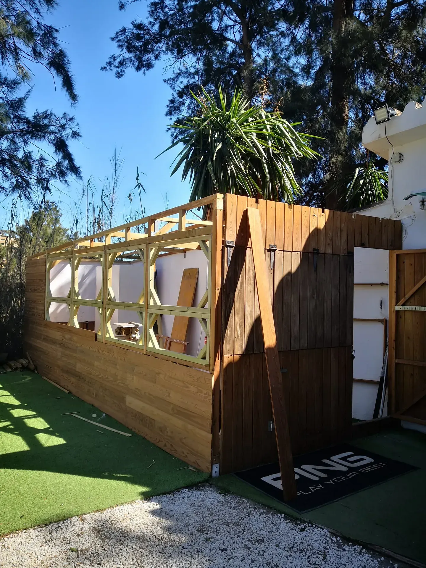 Se está construyendo una estructura de madera en el patio trasero de una casa.