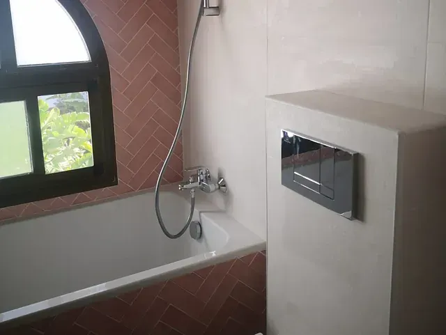 Un baño con bañera y ventana.