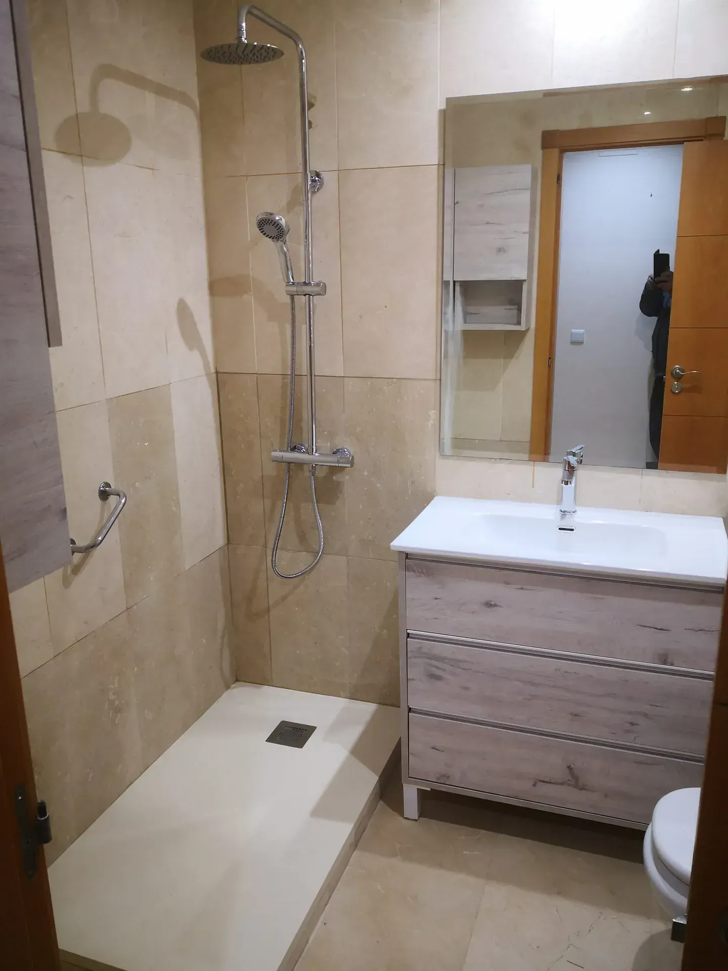 Un baño con ducha, lavabo y espejo.