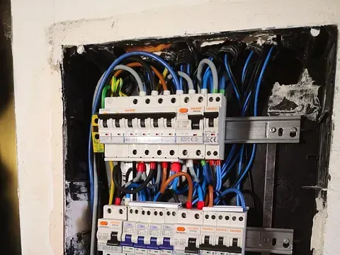 Un primer plano de una caja eléctrica con muchos cables saliendo de ella.