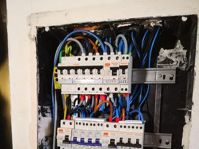 Un primer plano de una caja eléctrica con muchos cables saliendo de ella.