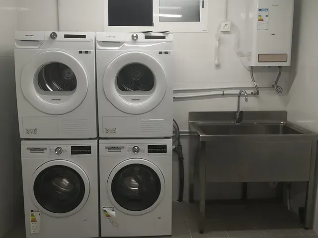 Una lavadora y una secadora están apiladas una encima de otra en un lavadero.