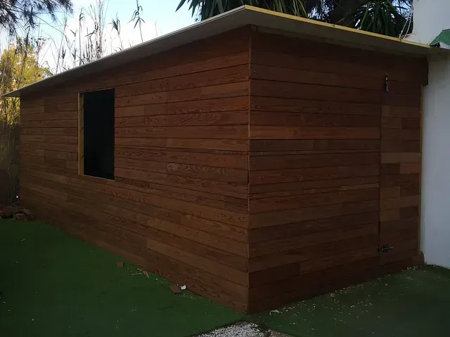 Un edificio de madera con una ventana en el costado.