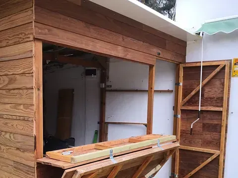 Se está construyendo un cobertizo de madera con la puerta abierta.