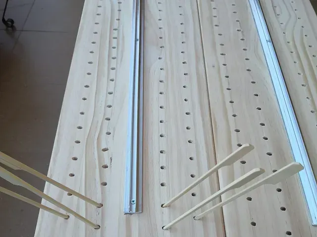 Una mesa de madera con agujeros y palillos sobre ella.