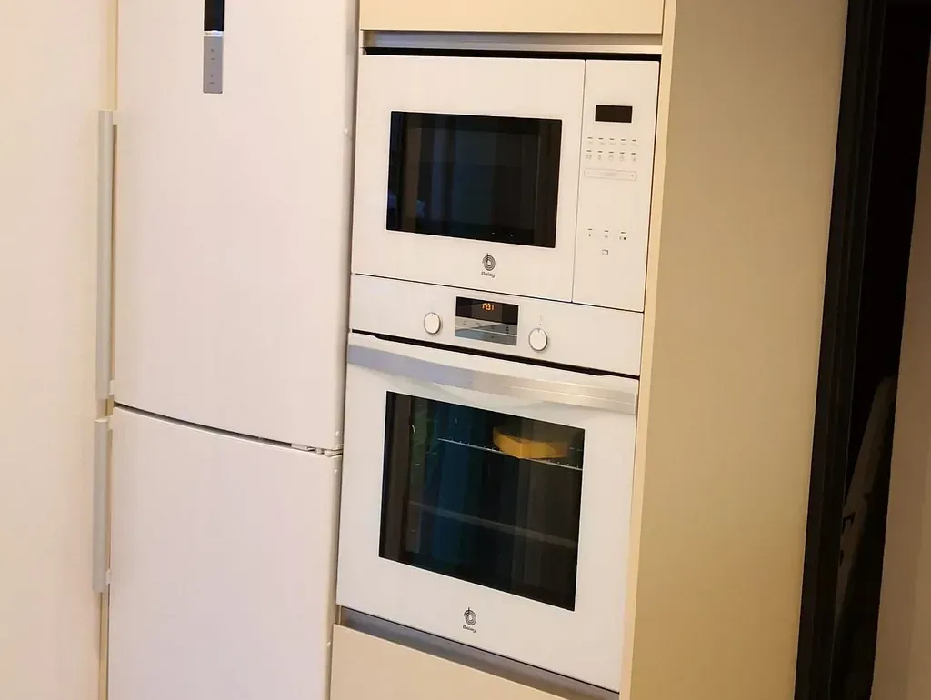 Un refrigerador blanco, un horno y un microondas en una cocina.