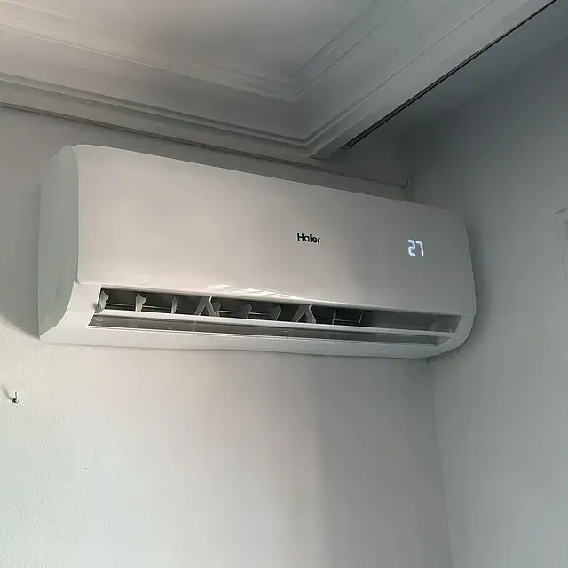 Un acondicionador de aire blanco cuelga del techo de una habitación.