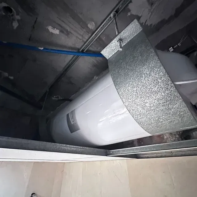 Una gran tubería blanca cuelga del techo de una habitación.