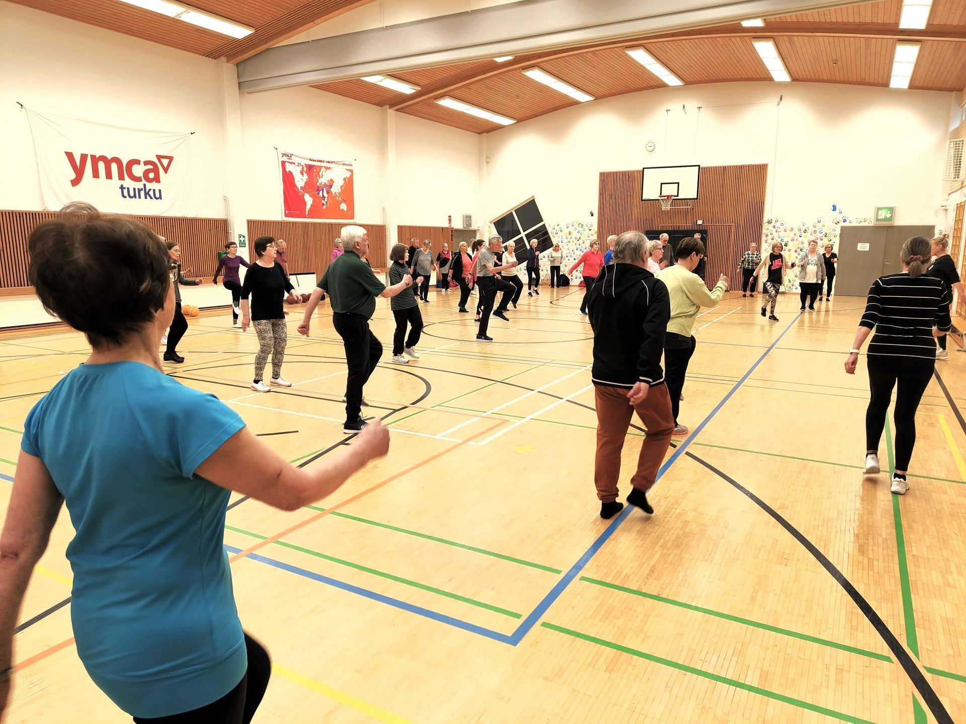 Ihmisiä treenaamassa liikuntasalissa.