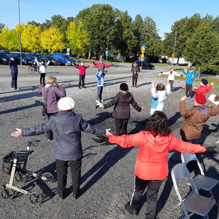 Ryhmä ihmisiä ulkona jumpaamassa.