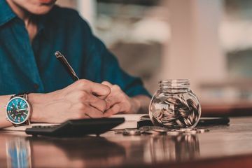 Työntekijä tekee kirjanpitoa paperilla