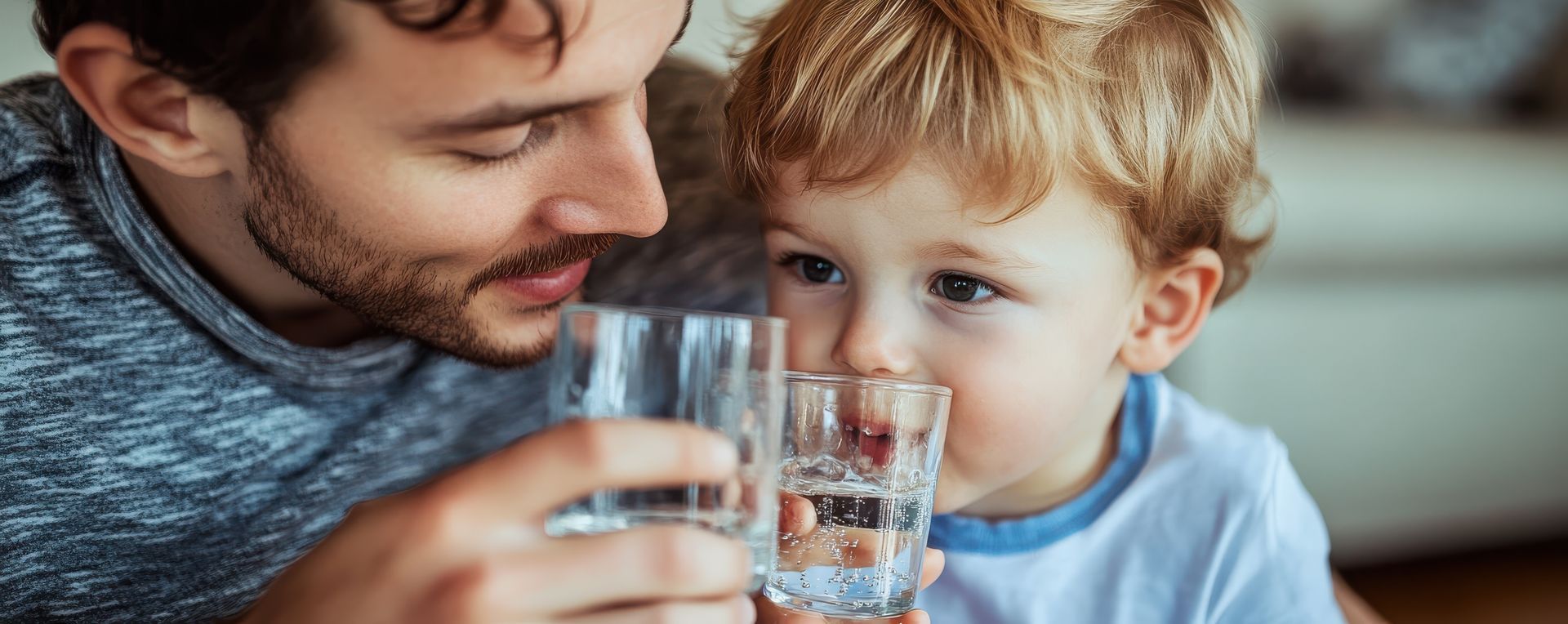 Papa et son bébé avec deux verres d'eau traitée