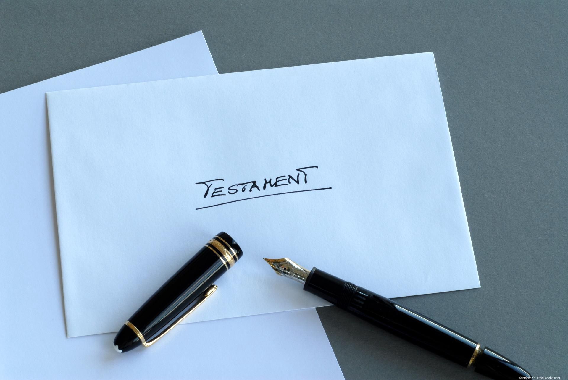 Ein weißer Umschlag mit der Aufschrift „Testament“ neben einem edlen Füllfederhalter.