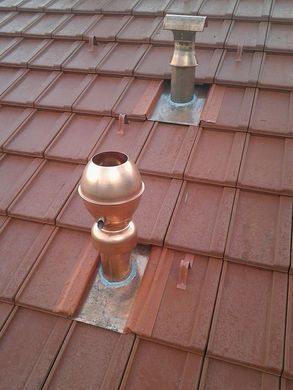 Il y a deux cheminées sur le toit d'un bâtiment.