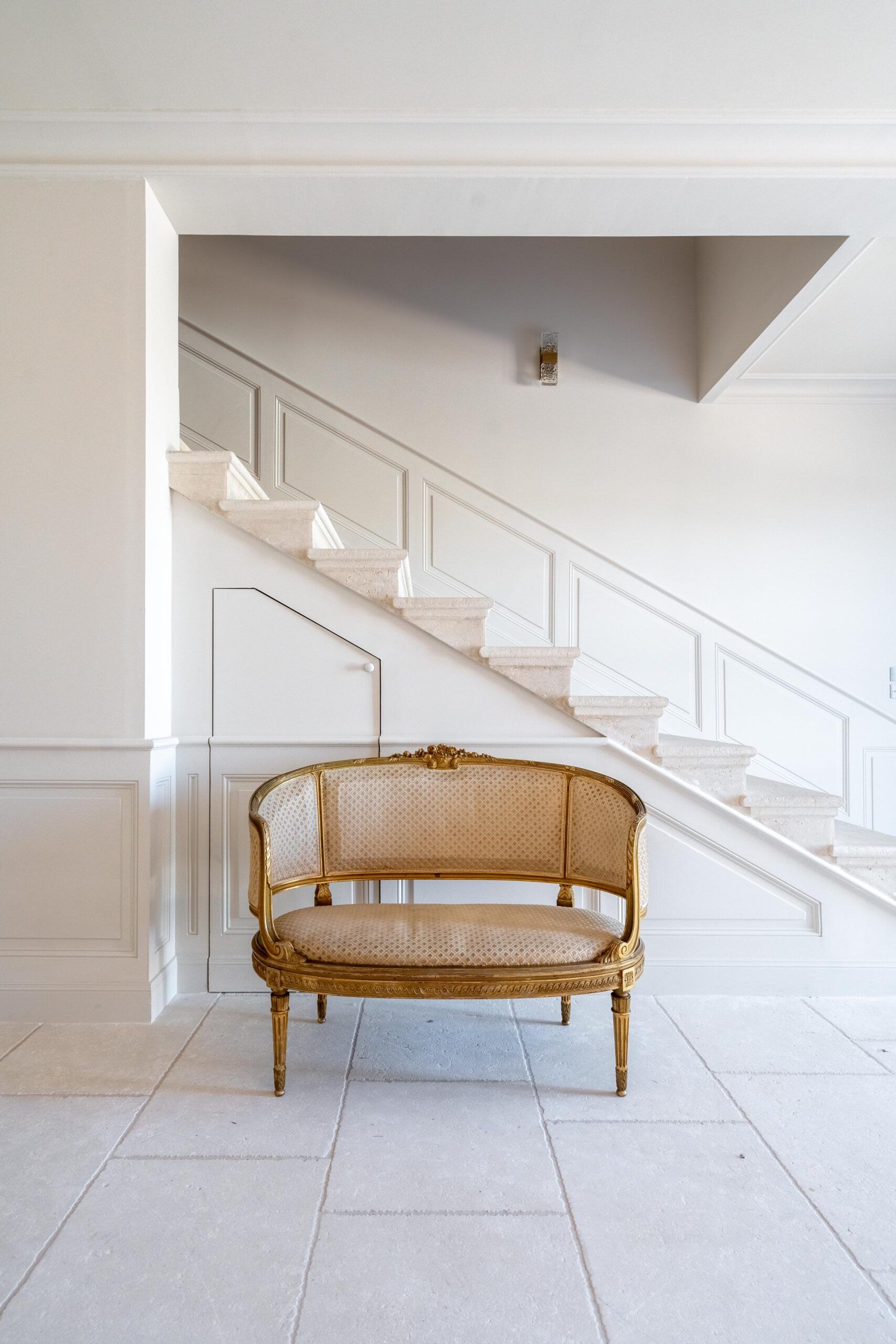 Un canapé est assis dans une pièce à côté d'un escalier.