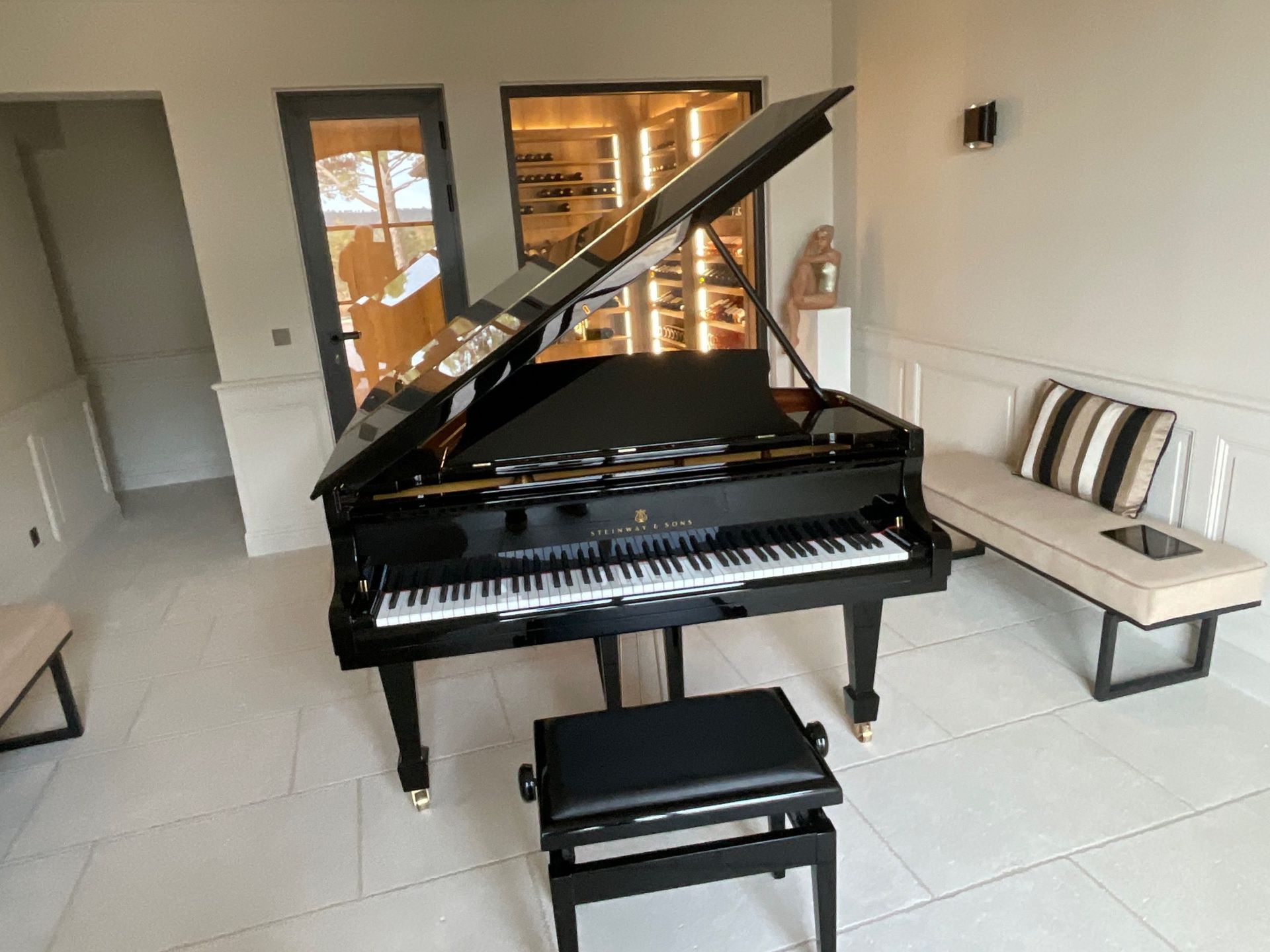 Un piano à queue est posé dans un salon avec son couvercle ouvert.