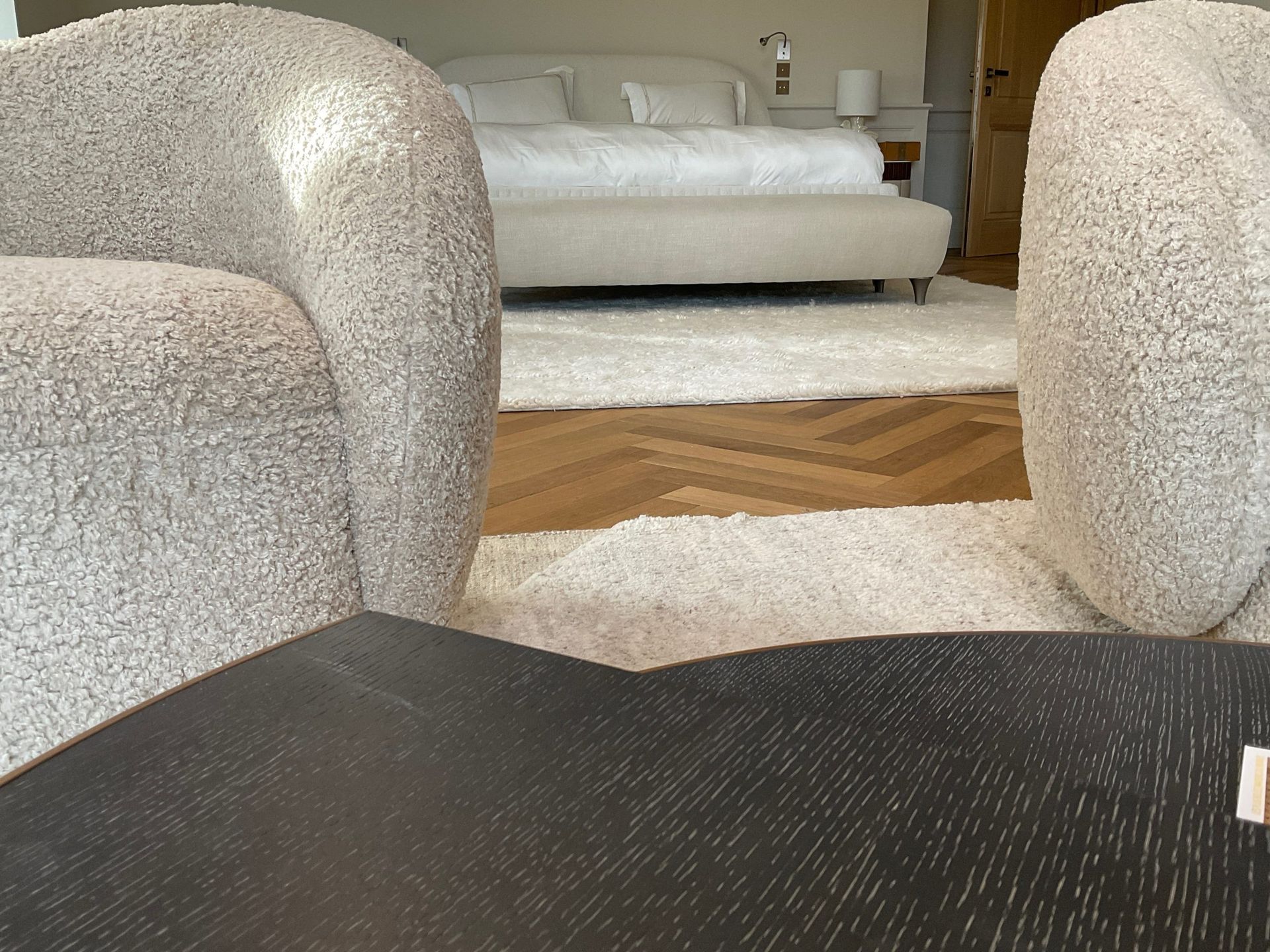 Une chambre avec deux chaises et un lit en arrière-plan