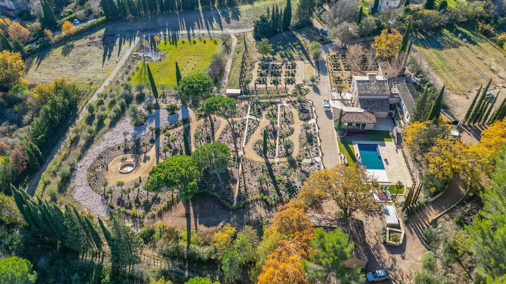 Une vue aérienne d'une grande maison entourée d'arbres et d'une piscine.