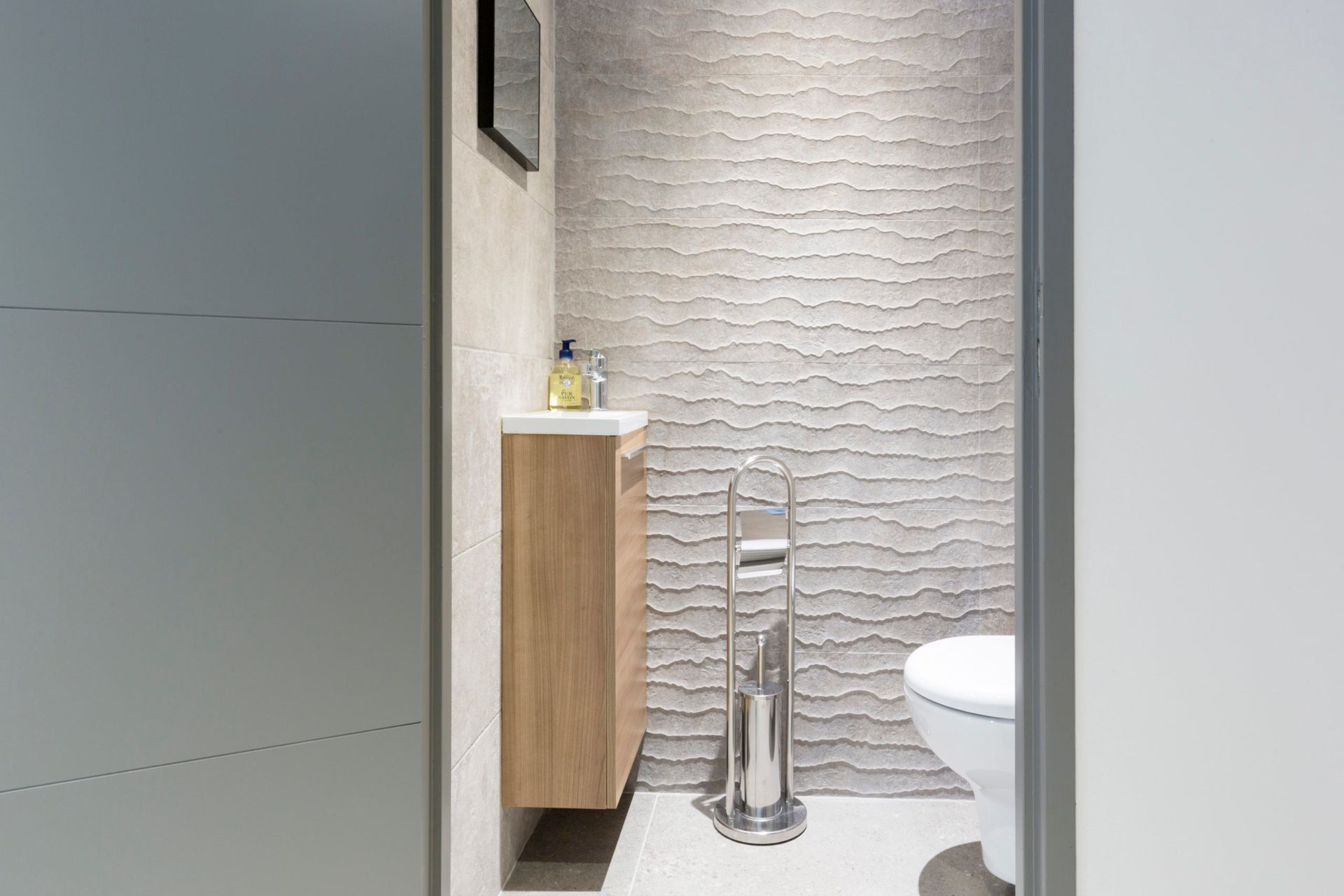 Une salle de bain avec WC, lavabo et miroir.