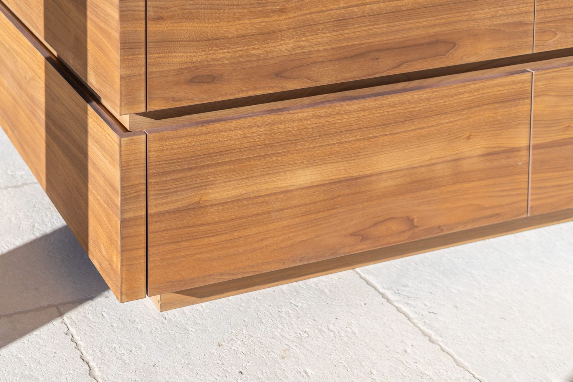 Un gros plan d'une commode en bois sur un sol en béton.