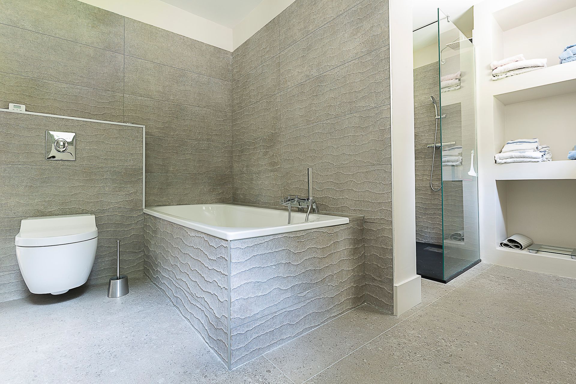 Une salle de bain avec baignoire, WC et douche.