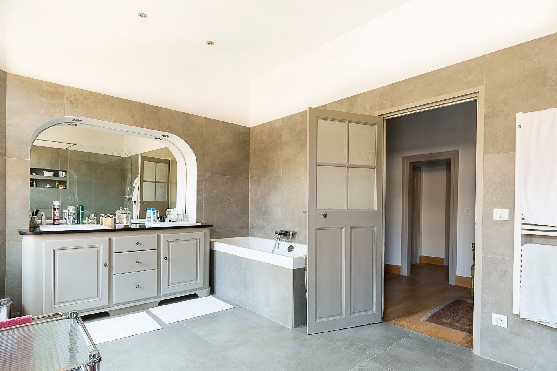 Une salle de bain avec baignoire, lavabo et miroir.