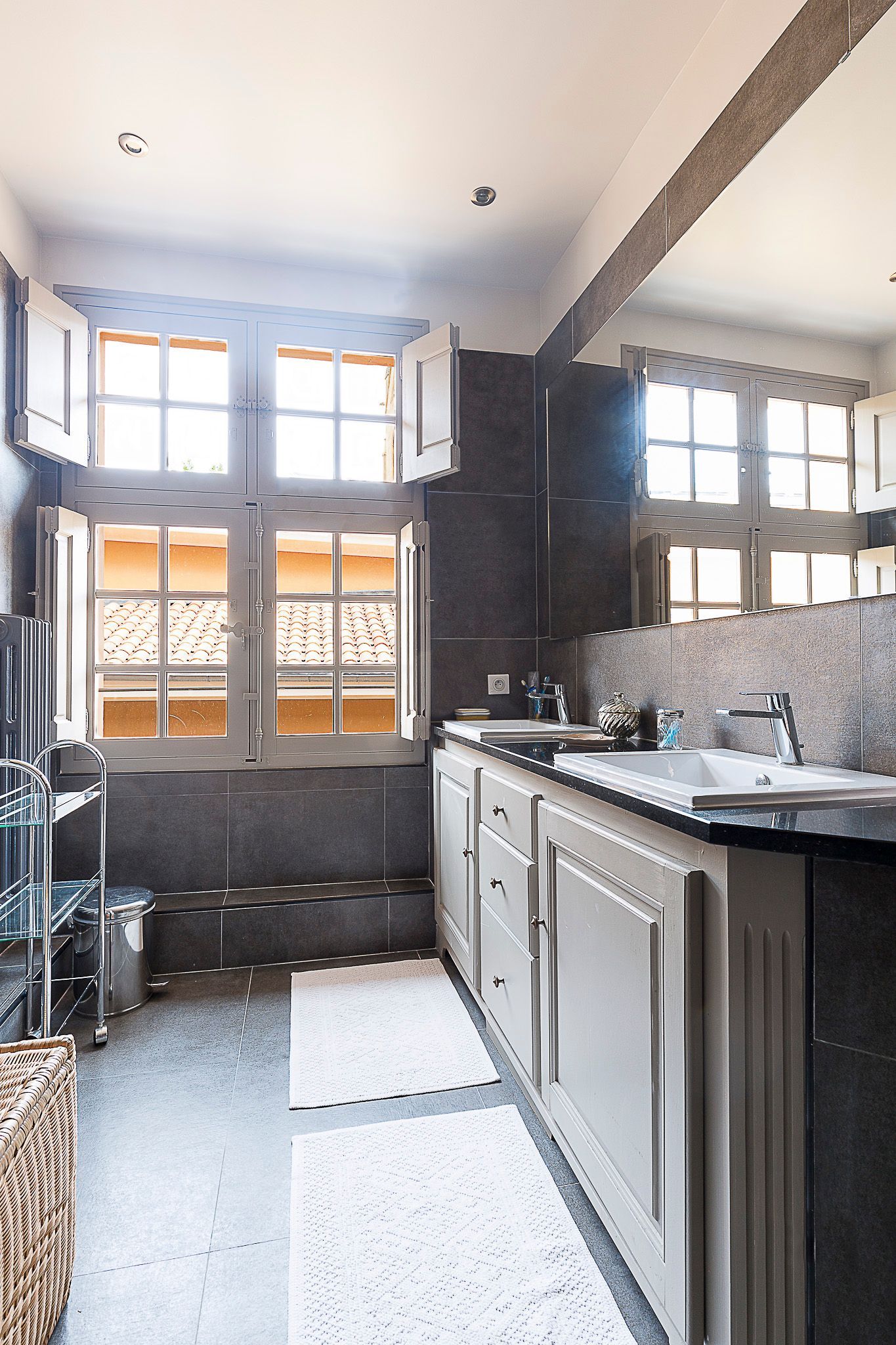 Une salle de bain avec deux lavabos et un grand miroir