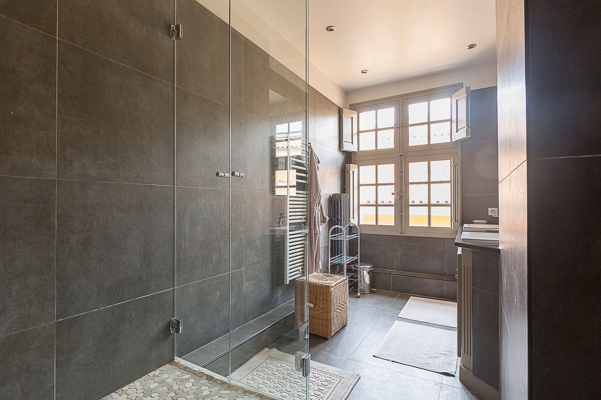 Une salle de bain avec une douche à l'italienne et une fenêtre