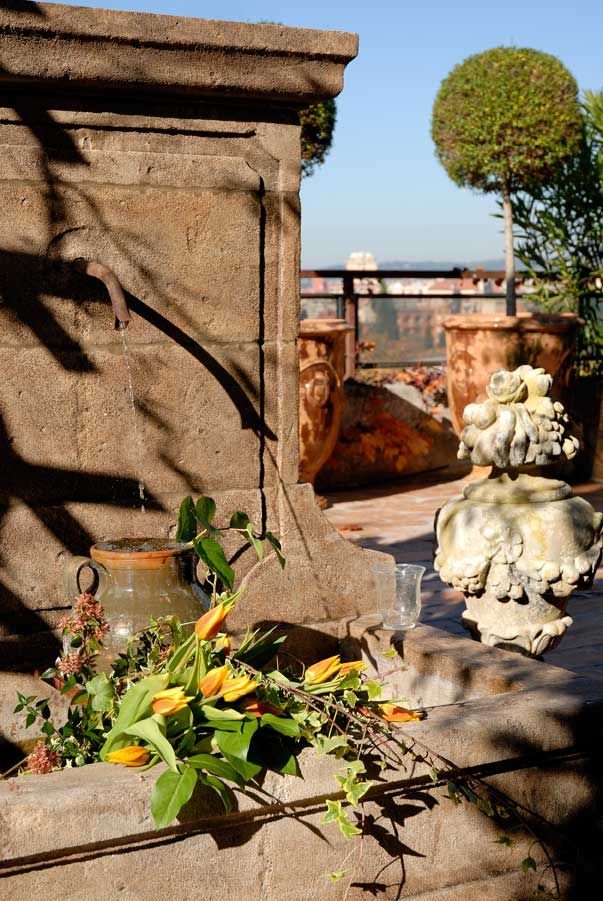 Un vase de fleurs se trouve devant un mur de pierre