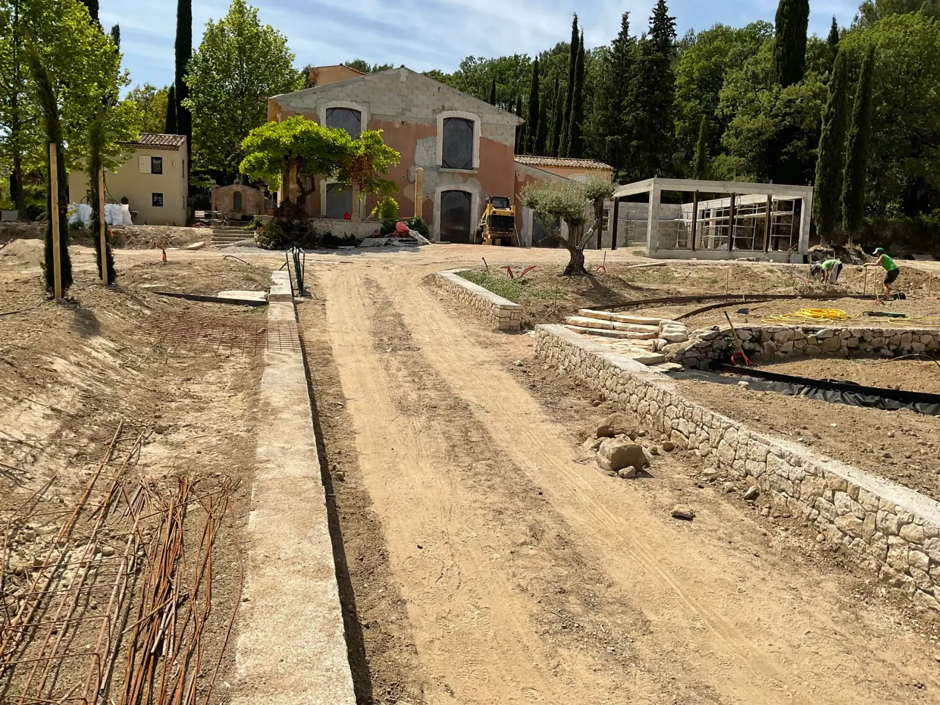 Un chemin de terre menant à une maison avec des arbres en arrière-plan