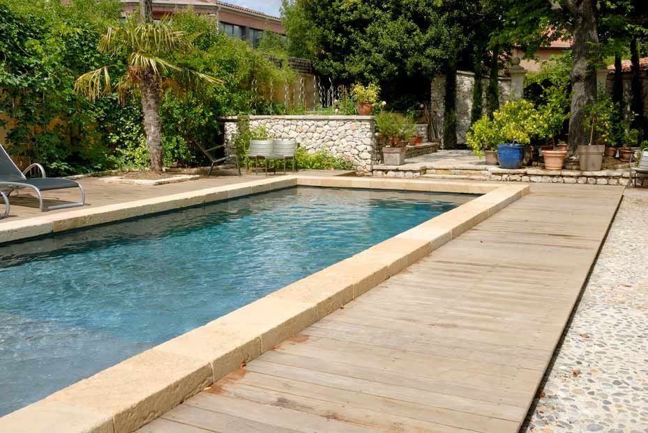 Une grande piscine avec une terrasse en bois autour