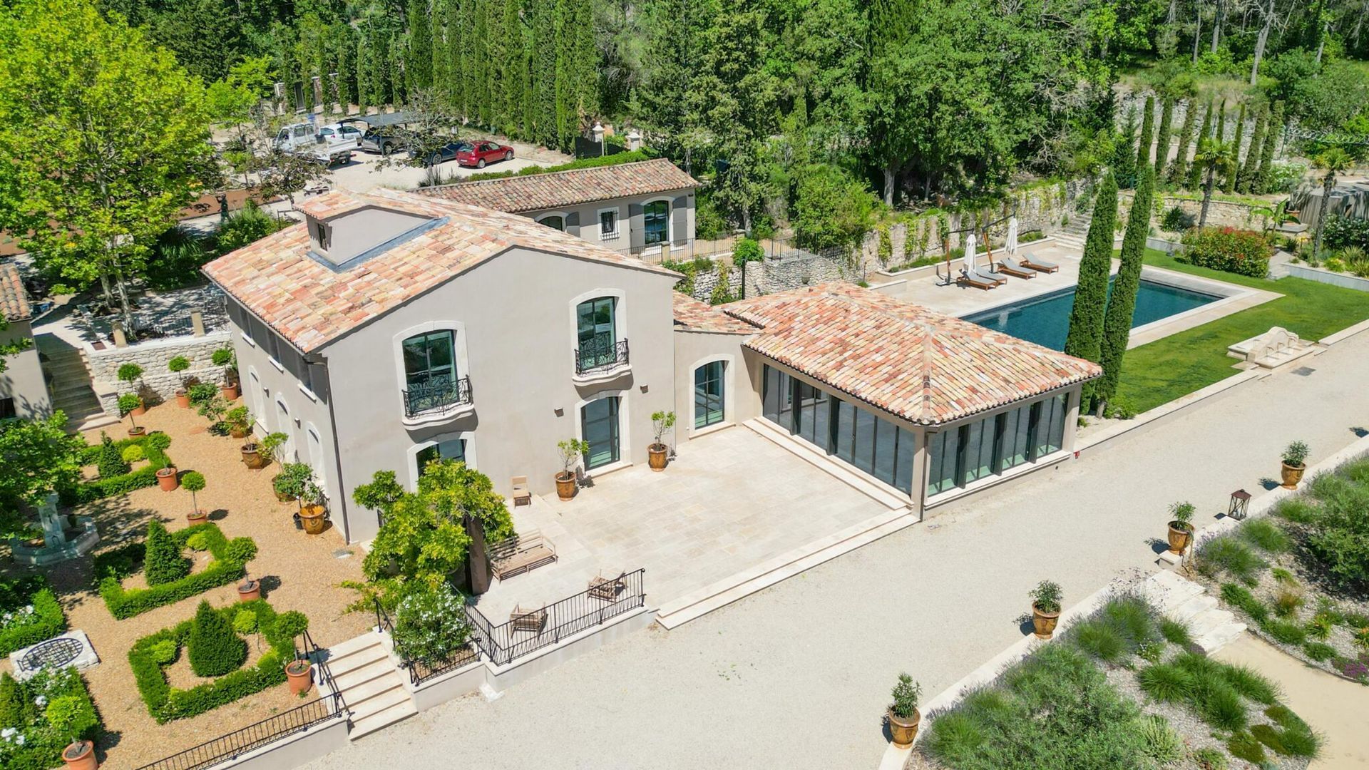 Une vue aérienne d'une grande maison avec piscine entourée d'arbres.