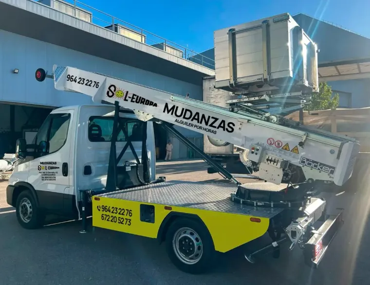 Camión de mudanzas blanco con elevador, detalles en amarillo y