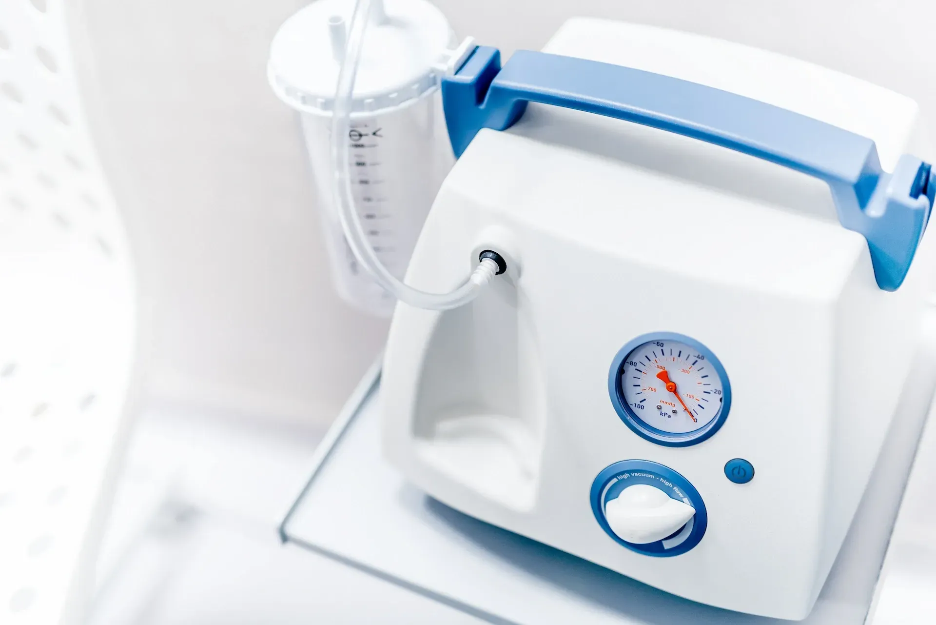 La mano de una persona presionando un botón en el panel de control de una bañera blanca.