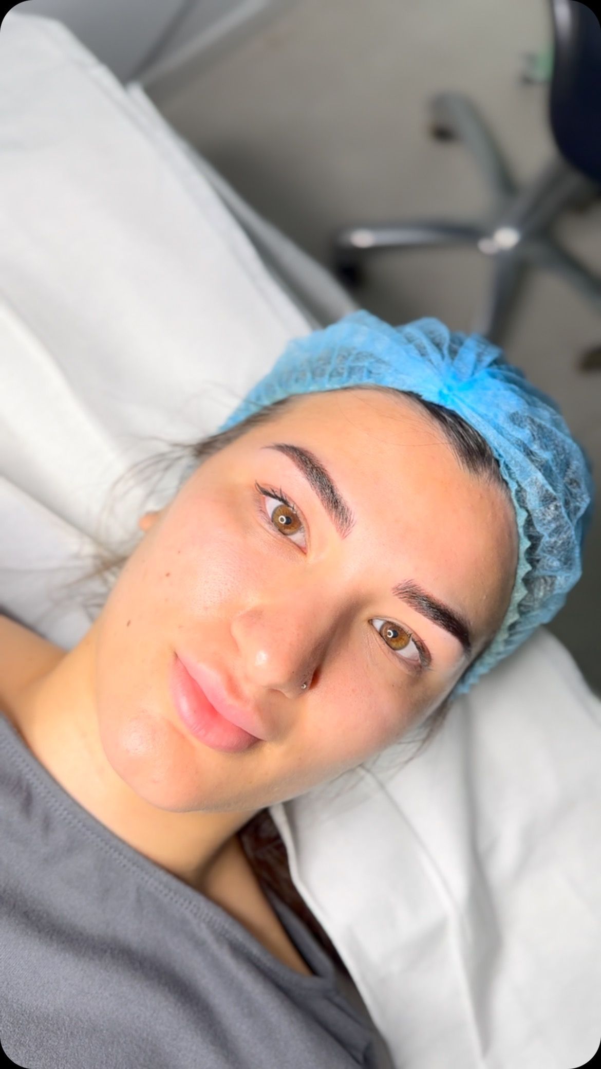 Una mujer que lleva un sombrero azul está acostada en una cama de hospital.