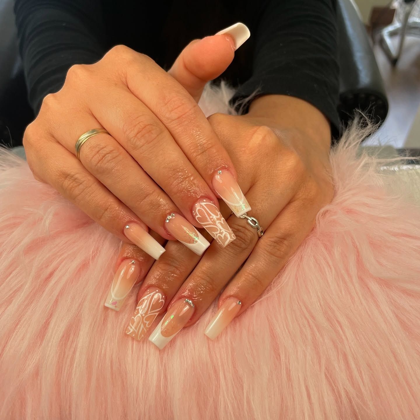 Las manos de una mujer con uñas largas y un anillo en el dedo.