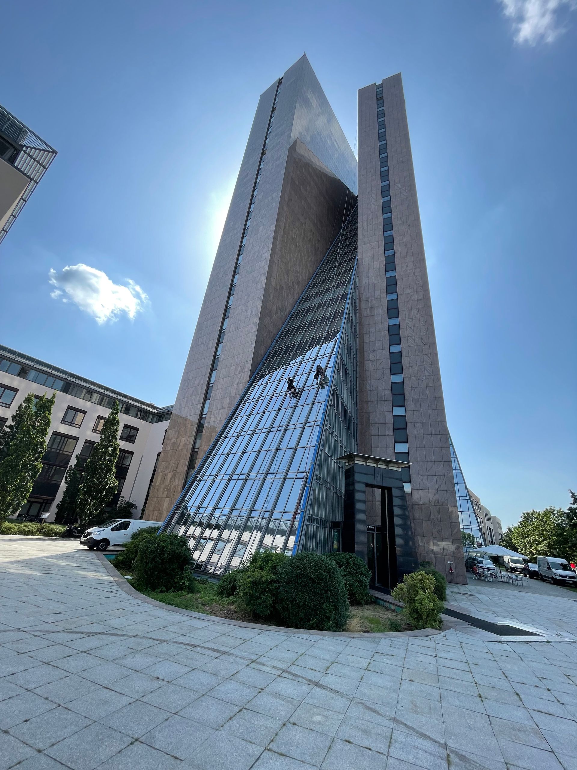Außergewöhnliches Gebäude mit schräger hoher Glasfront wird gereinigt