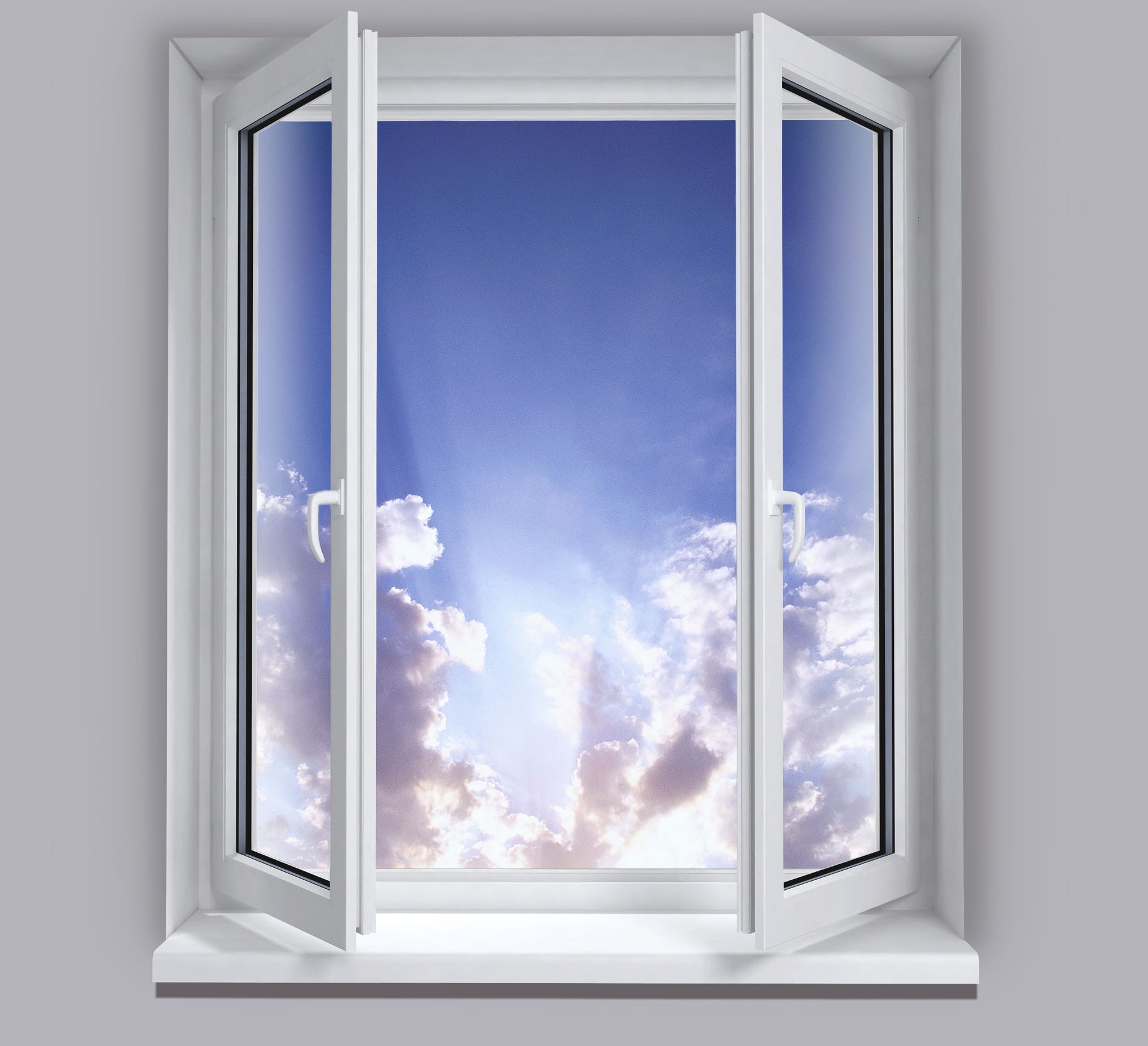 Fenêtre blanche ouverte donnant sur un ciel bleu éclatant et des nuages cotonneux.