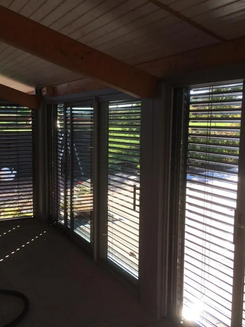 Pièce baignée de lumière grâce à ses nombreuses fenêtres, occultées par des stores horizontaux