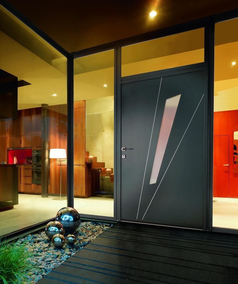 Porte d'entrée grise moderne à motif géométrique, intégrée dans une structure vitrée.