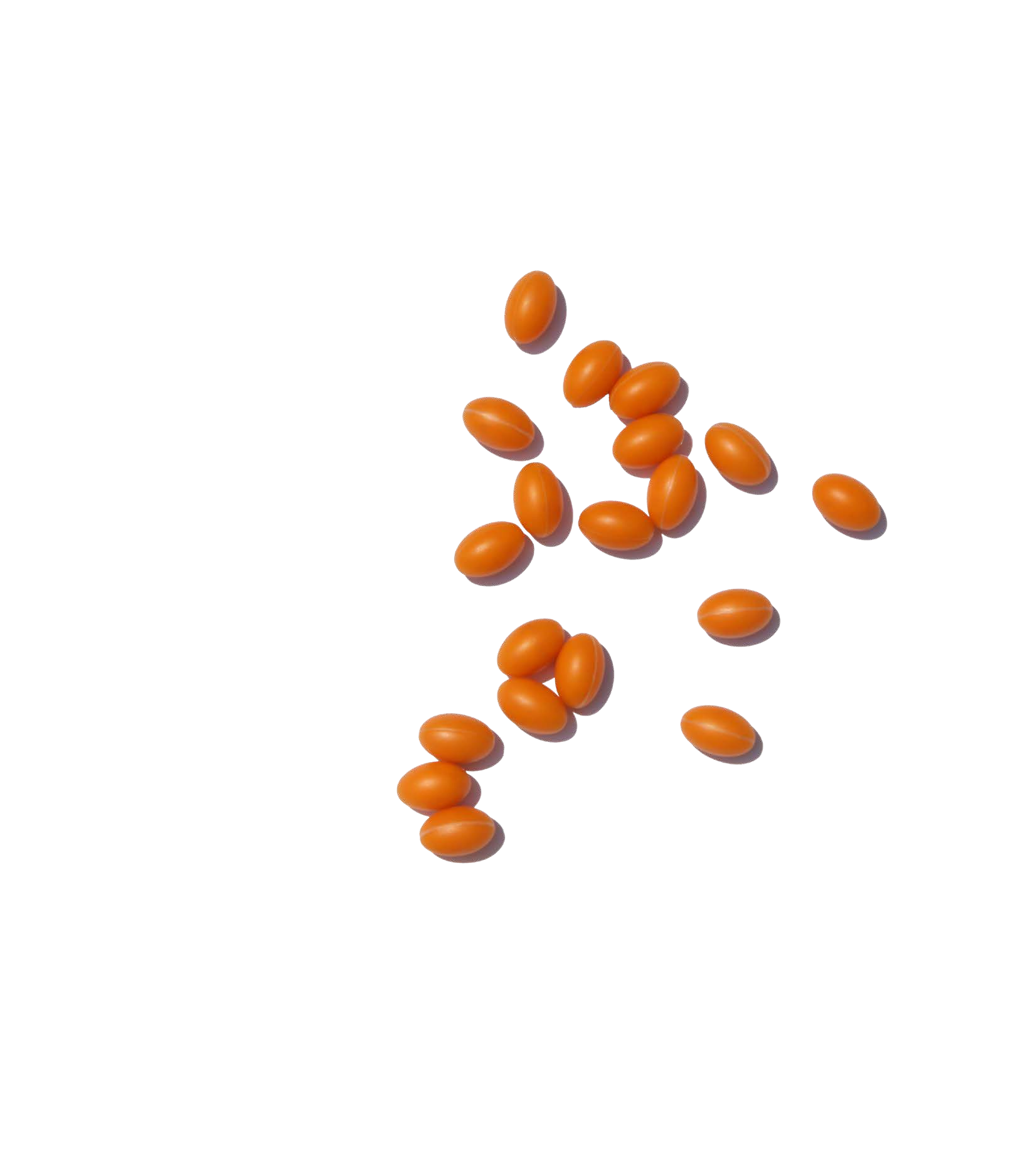 Pastillas ovaladas de color naranja esparcidas sobre una superficie blanca.