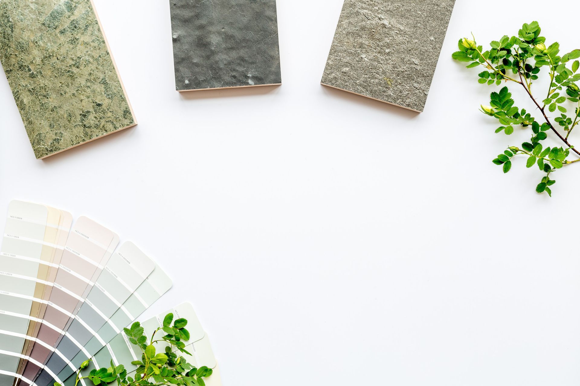 Una paleta de pinturas, azulejos y una planta sobre un fondo blanco.