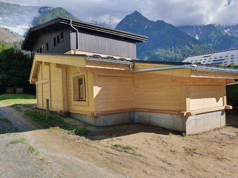 Petite maison en bois avec un toit en pente dans un cadre rural de montagne