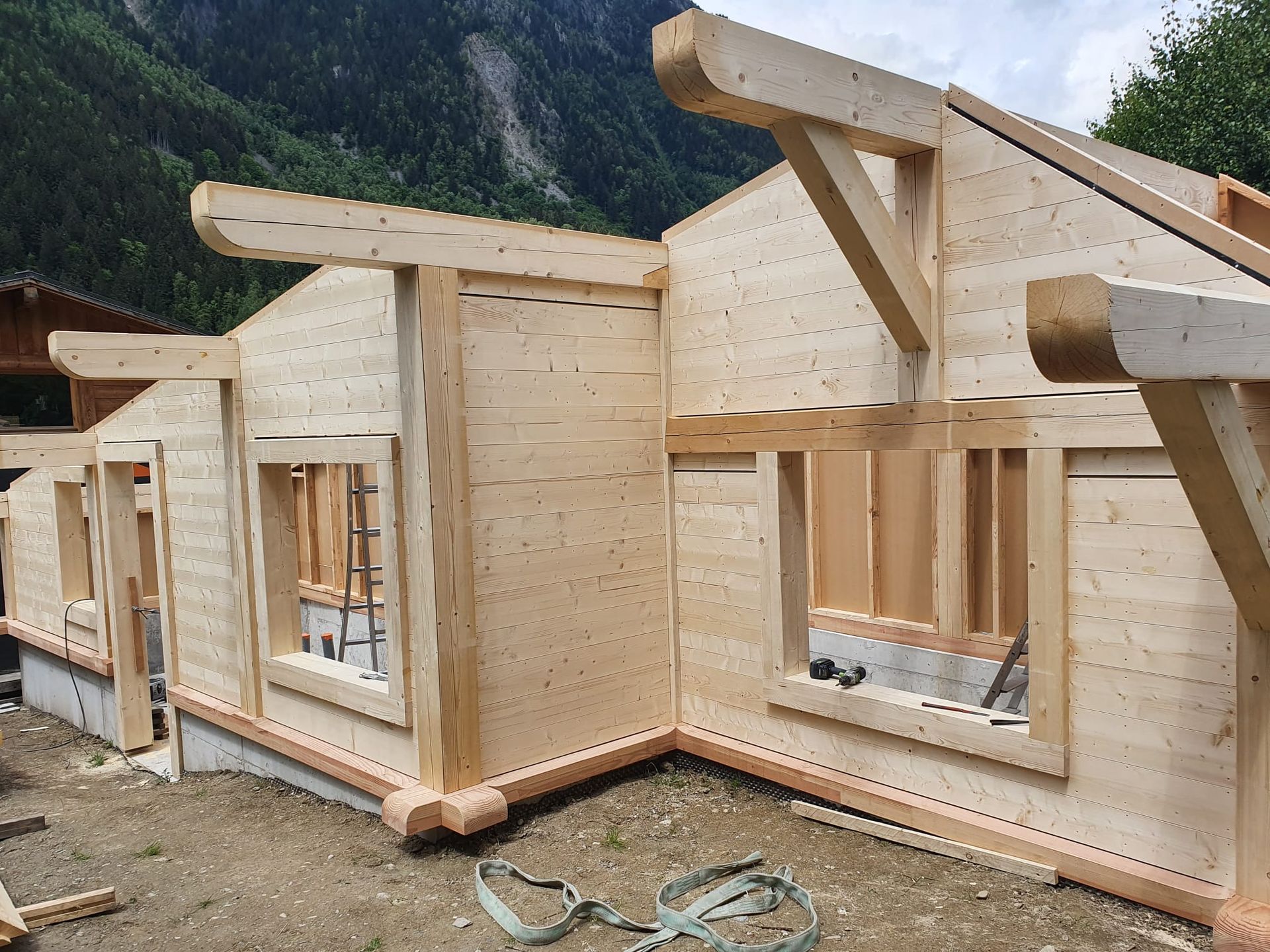 Charpentes de cabanes en bois en construction dans un cadre montagneux