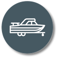 White outline of a motorboat on a trailer inside a dark blue circle.