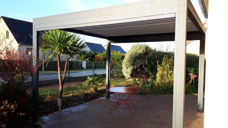 Terrasse couverte avec chaises rouges, plantes en pot et vue sur le jardin en plein jour