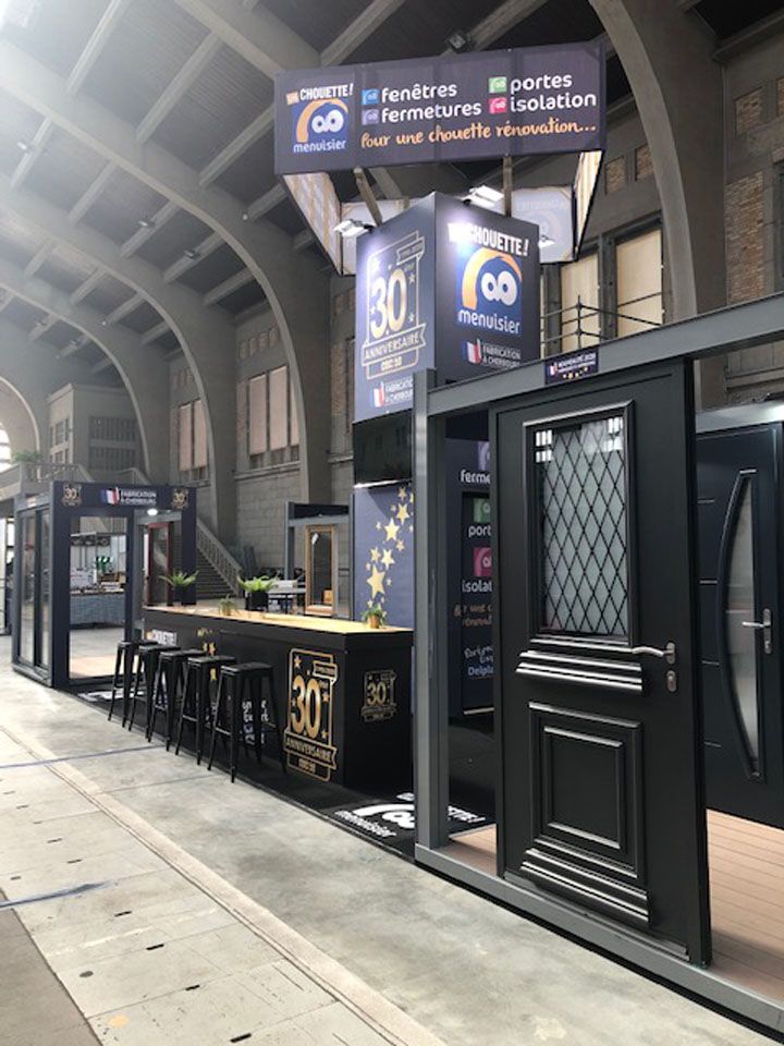 Guichet de paris sportifs noir sur le quai d'une gare, avec comptoirs et portes sombres, sous une enseigne « innovation sportive ».