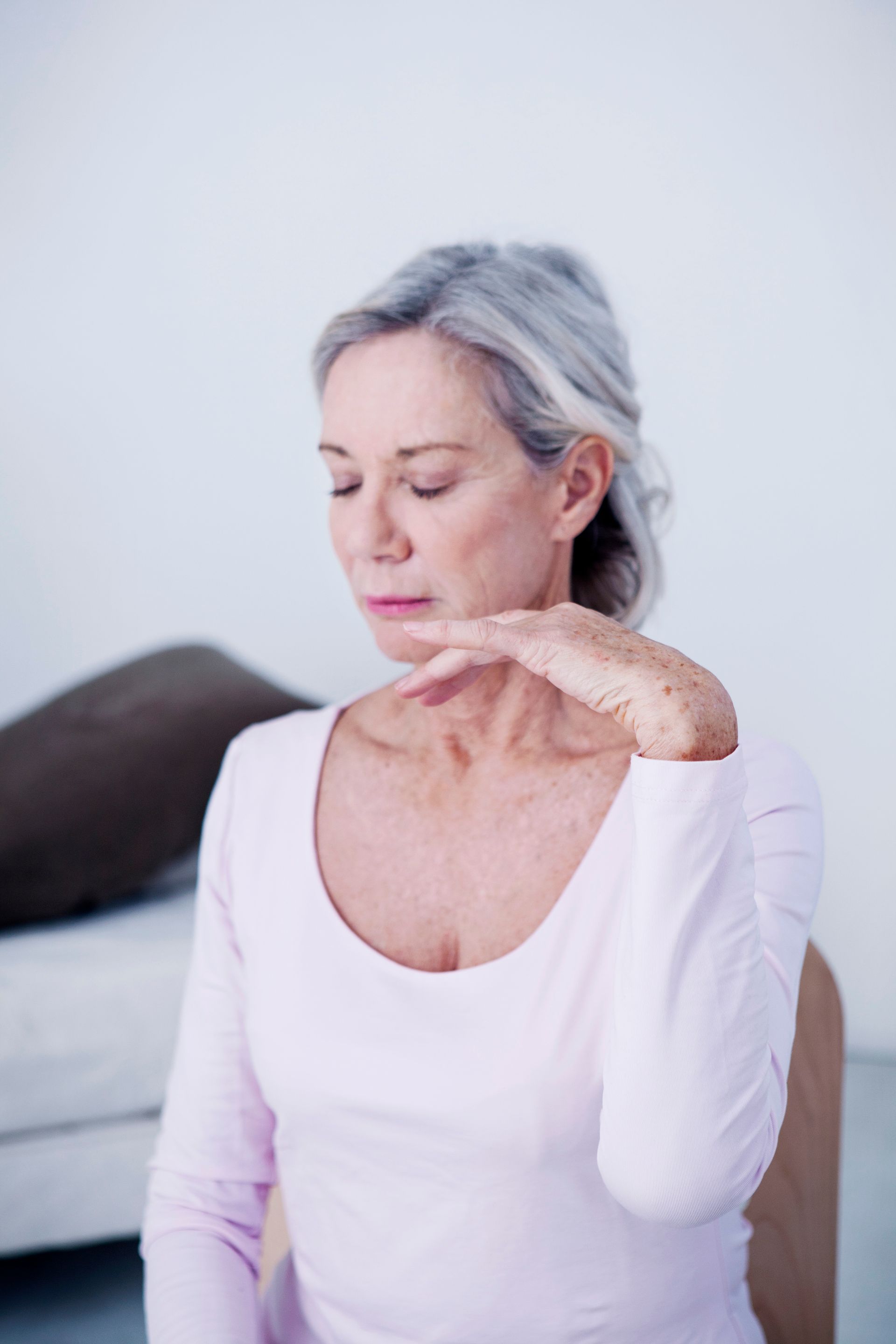 Femme avec le bras levé et les yeux fermés durant une séance d'hypnose - Sonia Bahouth psychologue, Cabinet Sagita